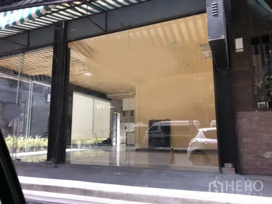 Retail Space for rent in Khlong Toei, Bangkok - Ground-floor retail unit with full-height glass facade, striped awning, and open-plan interior in Khlong Toei, Bangkok.