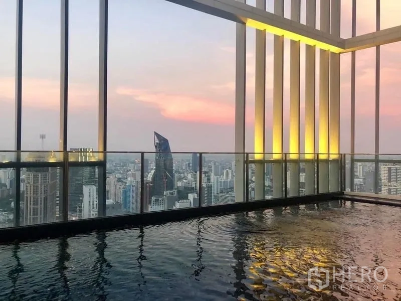 Condominium for rent in Khlong Toei, Bangkok - Rooftop infinity pool with panoramic Bangkok city views at sunset.