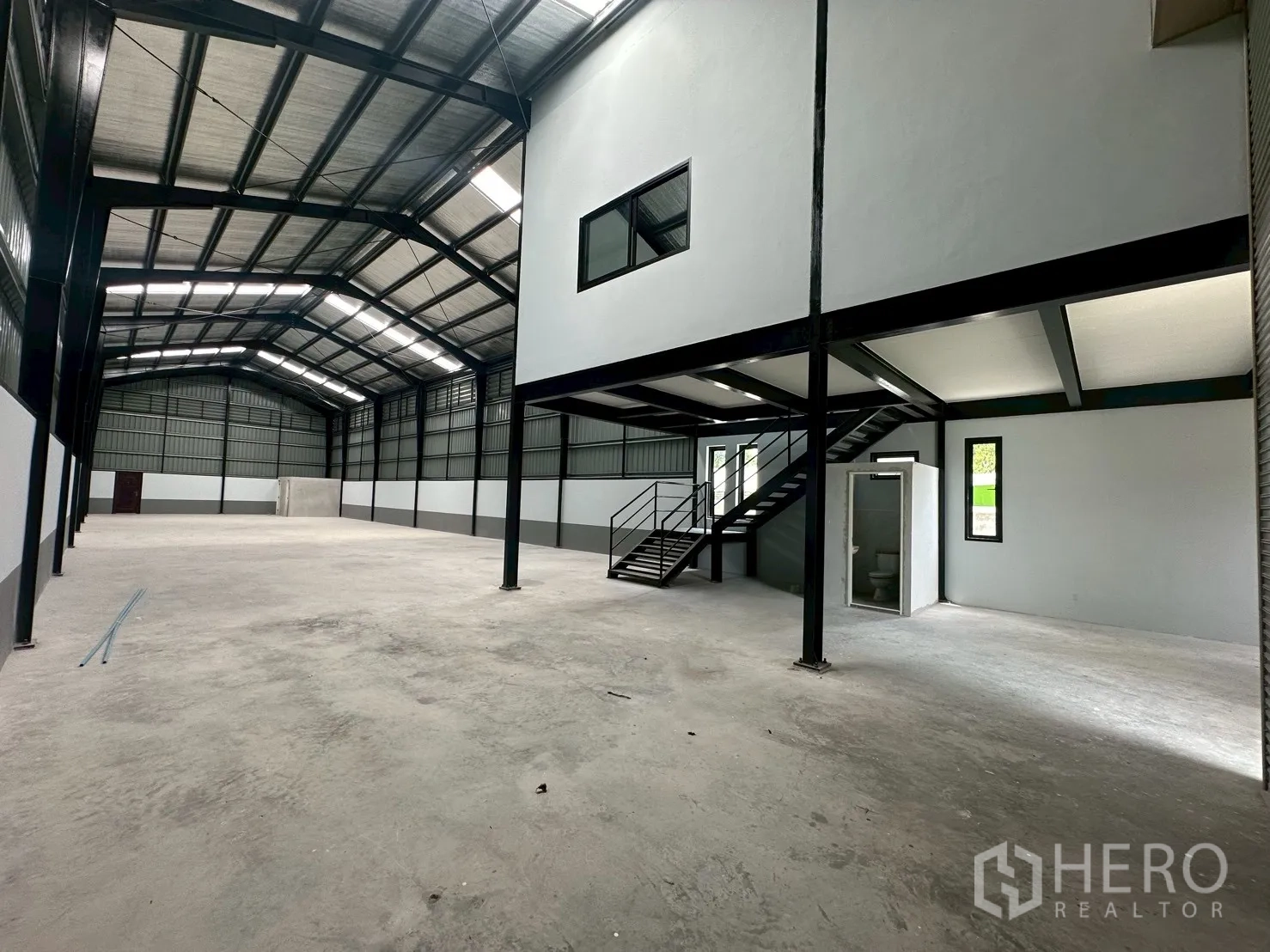 Warehouse for rent in Suan Luang, Bangkok - Large warehouse hall with high ceiling, staircase to office mezzanine and restroom.