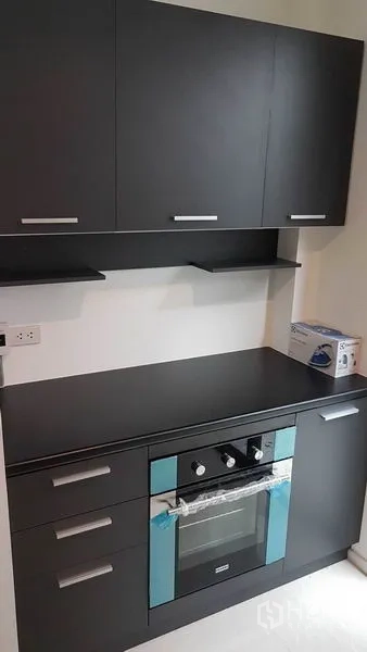 Detached House for rent in Prawet, Bangkok - Compact modern kitchen with dark cabinets and built-in oven.