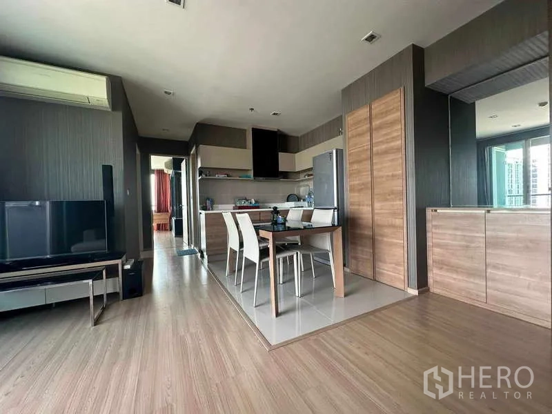 Condominium for sale in Phaya Thai, Bangkok - Open kitchen with dining table for four, wood cabinetry, and built‑in storage.