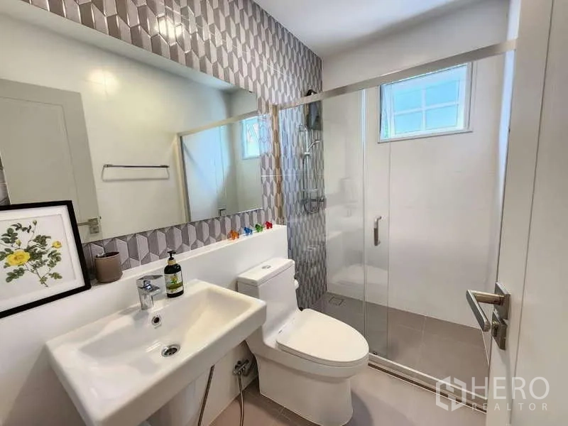 Detached House for rent or sale in Bang Phli, Samut Prakan - Bathroom with geometric feature wall and glass shower enclosure.