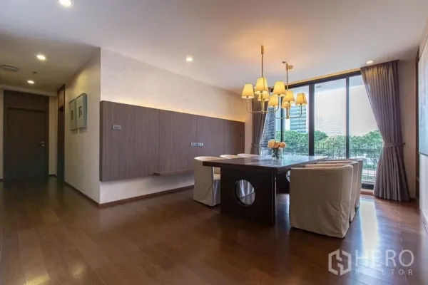 Condominium for rent or sale - Dining room with chandelier, large windows and balcony-style sliding doors.