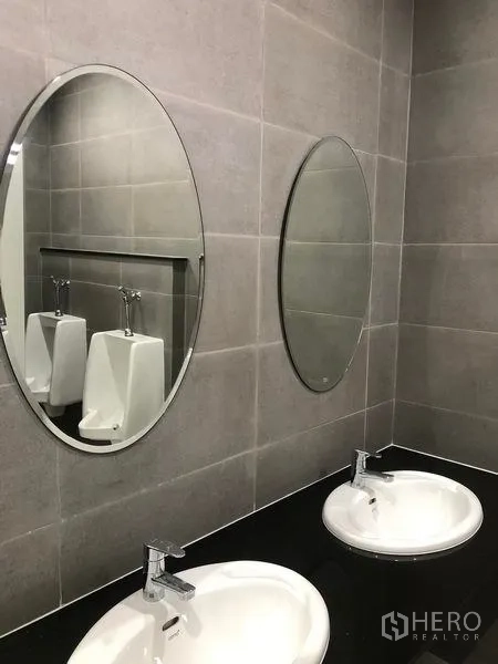 Factory for rent in Wang Noi, Phra Nakhon Si Ayutthaya - Modern restroom with twin round mirrors, tiled walls, and ceramic basins.