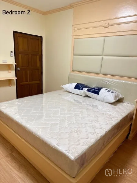 公寓 出租在Watthana, Bangkok - 简洁卧室，软包床头与木门