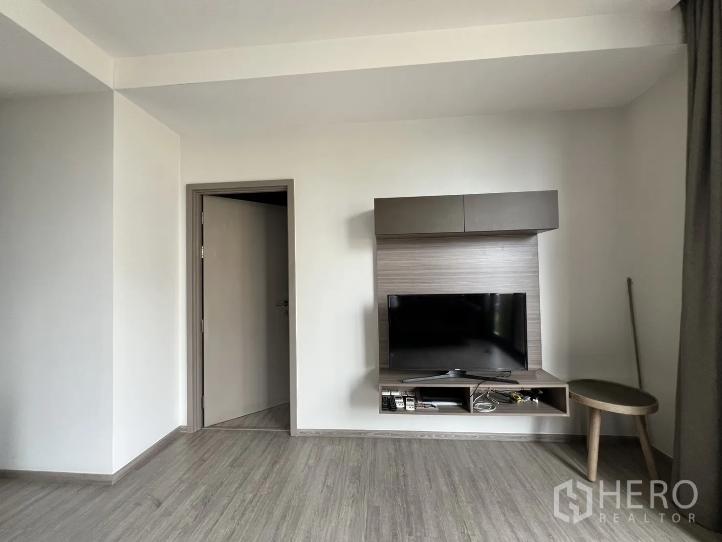 คอนโด for rent in Watthana, Bangkok - ผนังทีวีลายไม้พร้อมชั้นวางลอยและโต๊ะข้างเล็ก