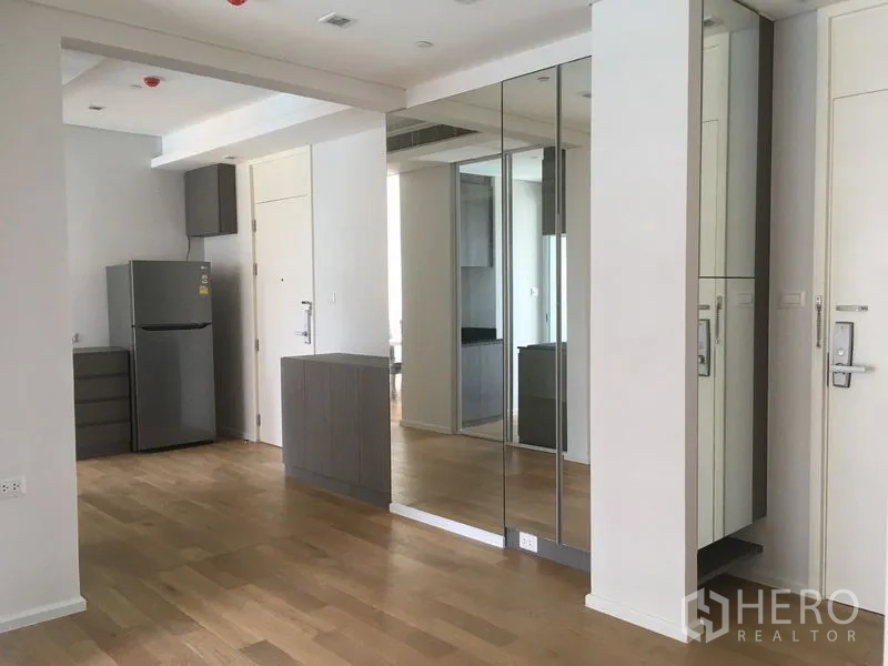 Condominium for rent or sale in Chatuchak, Bangkok - Open-plan entry with mirrored wardrobes, wood flooring and a stainless refrigerator.