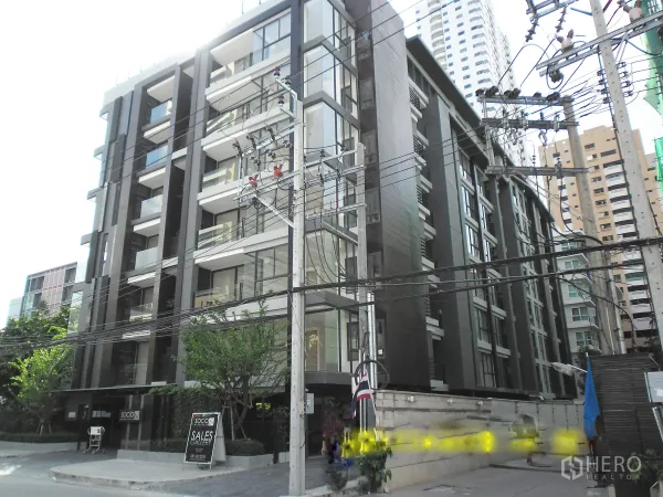 Condominium for rent or sale in Watthana, Bangkok - Modern mid-rise condominium exterior with glass balconies on a quiet Sukhumvit side street in Watthana.
