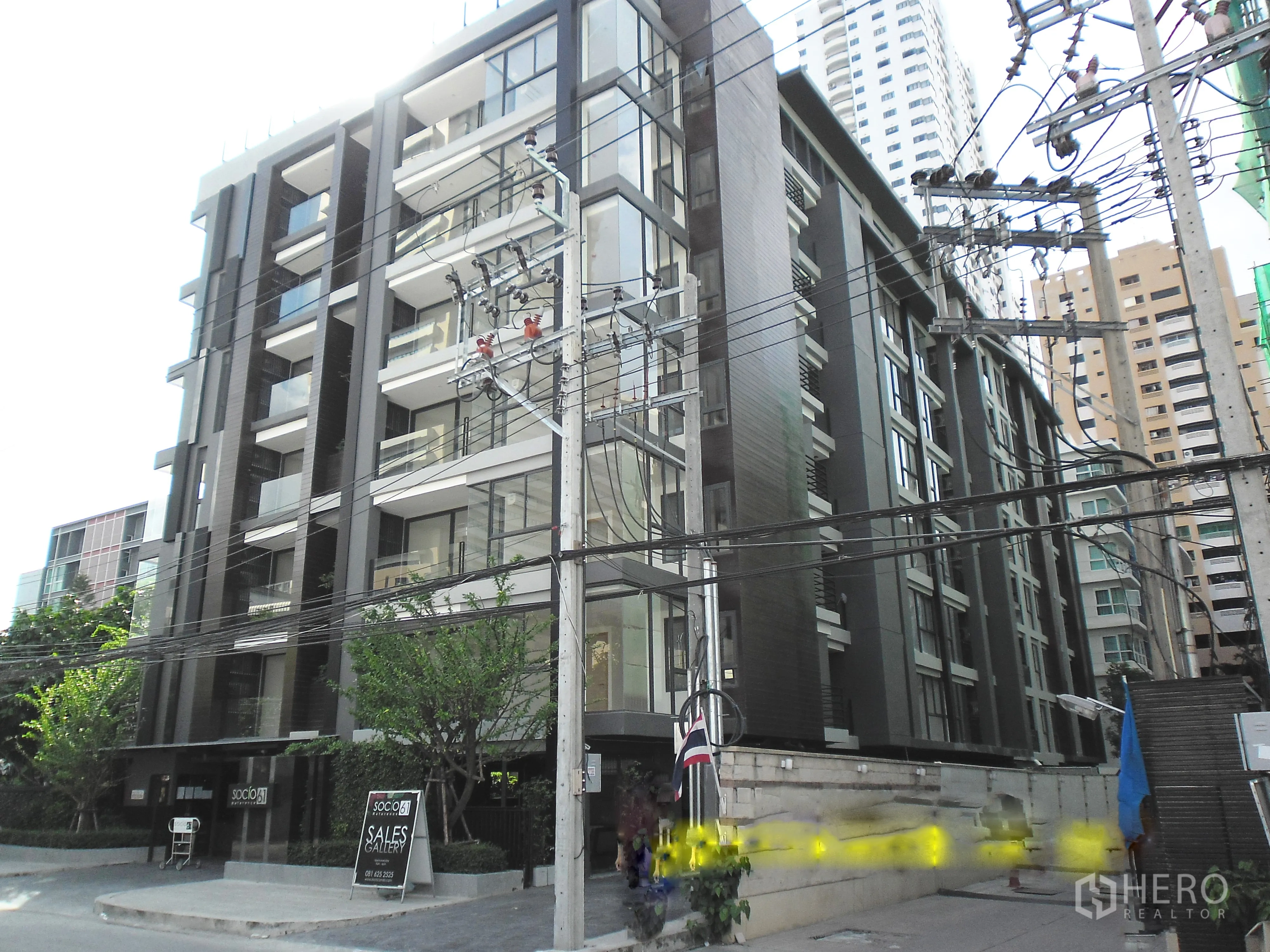 Condominium for rent or sale in Watthana, Bangkok - Modern mid-rise condominium exterior with glass balconies on a quiet Sukhumvit side street in Watthana.