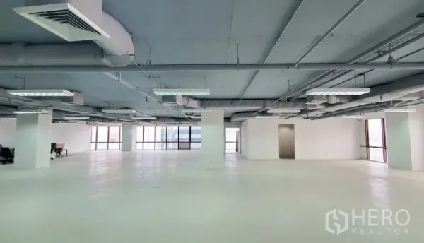 办公空间 出租在Watthana, Bangkok - 白色地面的大空间办公区，立柱与吊顶空调，自然采光充足