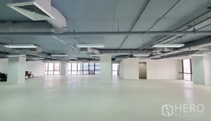 办公空间 出租在Watthana, Bangkok - 白色地面的大空间办公区，立柱与吊顶空调，自然采光充足