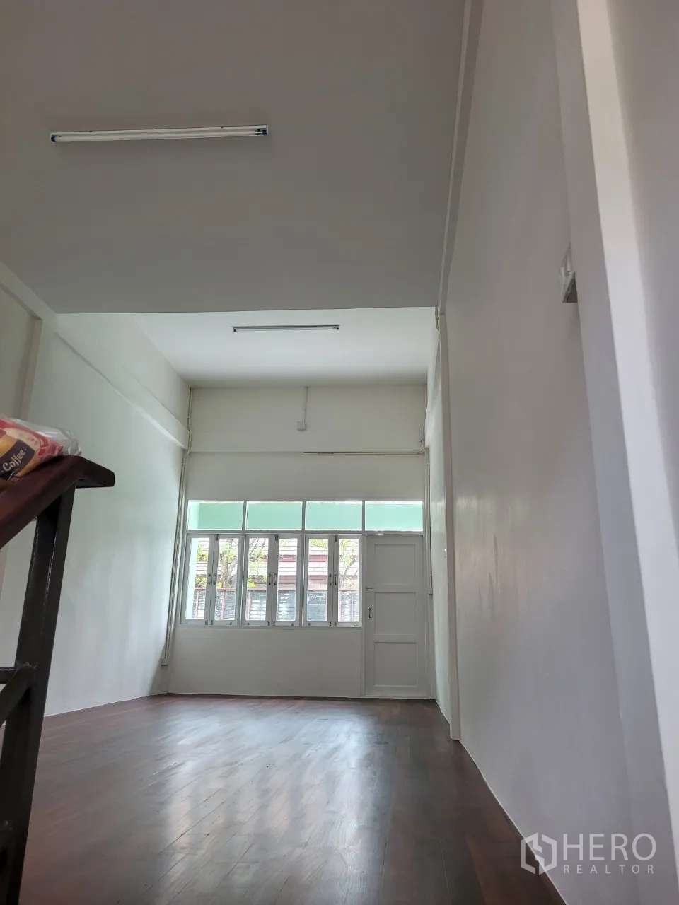 Shophouse for rent in Khlong Toei, Bangkok - Upper floor open room with wide windows, natural light and wood flooring.