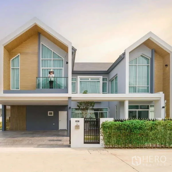 Detached House for sale in Lam Luk Ka, Pathum Thani - Modern two-storey detached house with twin gable roof, full-height windows and covered carport.