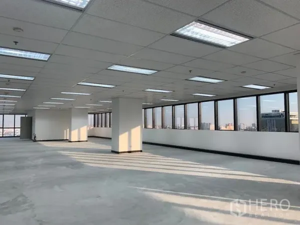 Office Space for rent in Din Daeng, Bangkok - Expansive office plate with a long window wall, central columns, and natural light across a concrete floor.