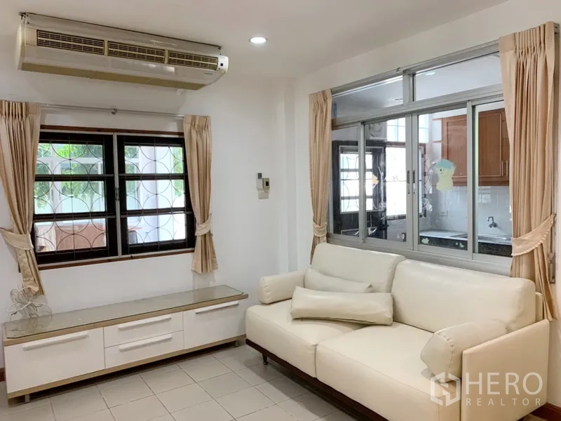 บ้าน ให้เช่าในKhlong Toei, Bangkok - มุมนั่งเล่นพร้อมโซฟา ตู้บิวท์อิน เครื่องปรับอากาศ และช่องหน้าต่างเชื่อมครัว