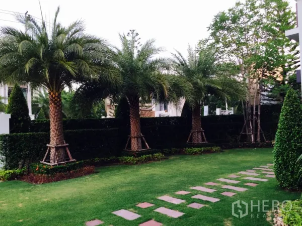 Detached House for sale in Lat Krabang, Bangkok - Landscaped garden with palm trees, neat hedges and a stepping-stone path.