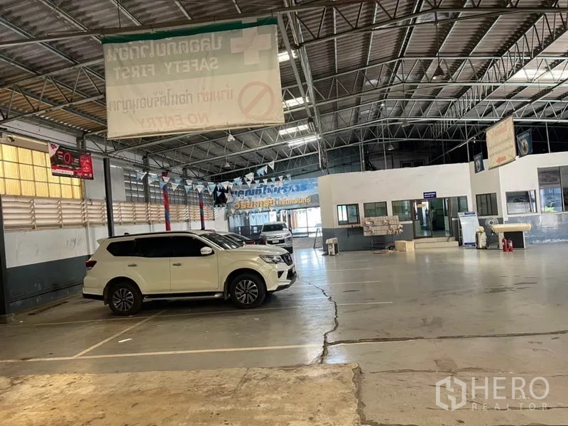 Warehouse for rent in Prawet, Bangkok - Indoor parking and loading area within the warehouse under a steel truss roof.