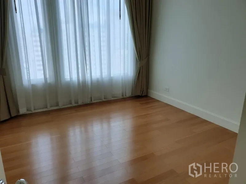 公寓 出租在Watthana, Bangkok - 温馨卧室，设有大窗与窗帘，木地板，简约公寓风格。
