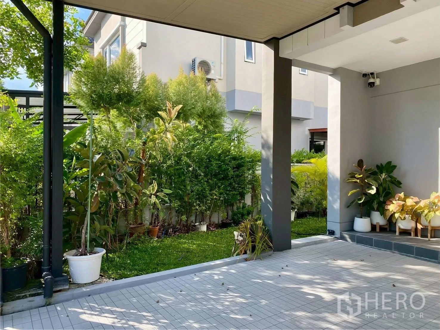 Semi-detached House for rent in Bang Phli, Samut Prakan - Covered carport and tiled patio beside a lush side garden of a semi-detached house in Bang Phli.