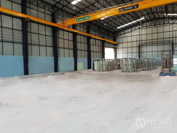 Warehouse for rent in Mueang Pathum Thani, Pathum Thani - Spacious warehouse interior with high steel truss ceiling, overhead gantry crane and smooth concrete floor for storage and production.