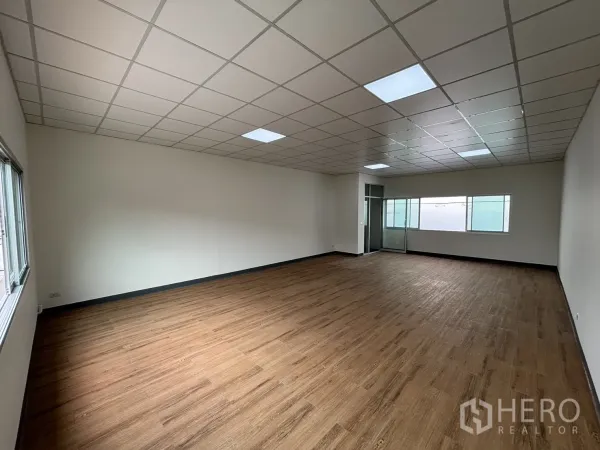 Retail Space for rent - Open-plan shop space with long windows and a glass partition at the far end.