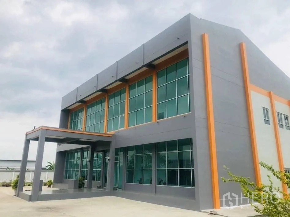 Factory for rent or sale in Bang Sao Thong, Samut Prakan - Front elevation of factory building with tall windows and canopy.