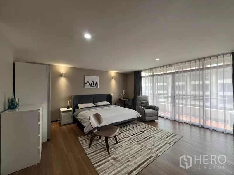 Townhouse for rent or sale in Suan Luang, Bangkok - Bedroom with panoramic windows, balcony and wood floors.