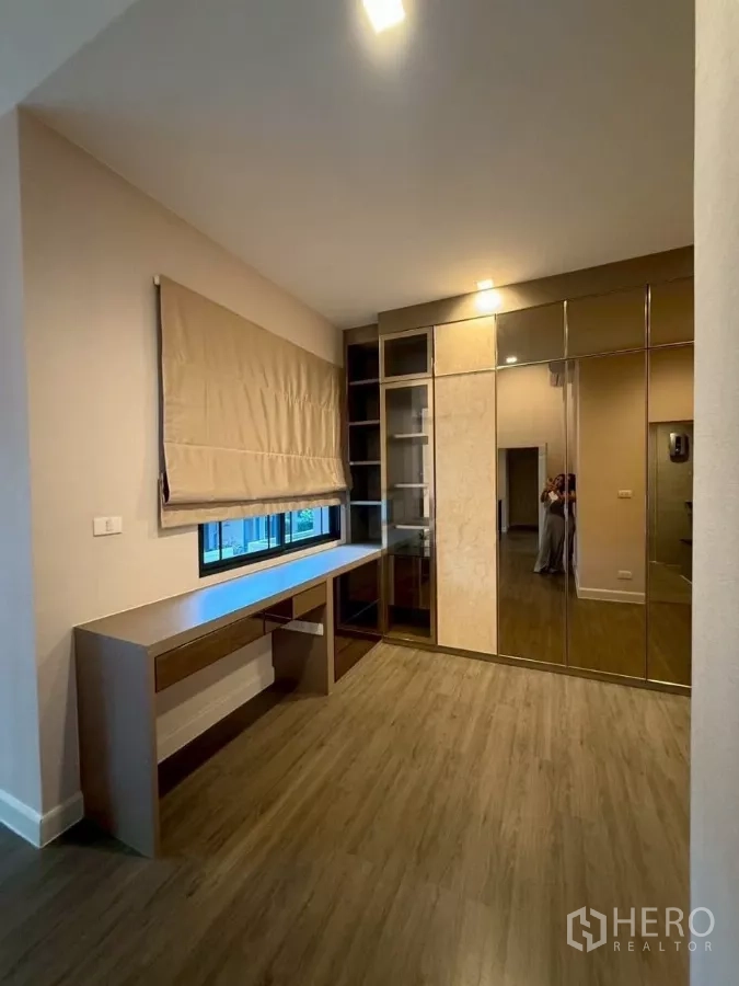 Detached House for rent or sale in Bang Phli, Samut Prakan - Dressing room with long built‑in desk, mirror‑front wardrobes and window blinds.