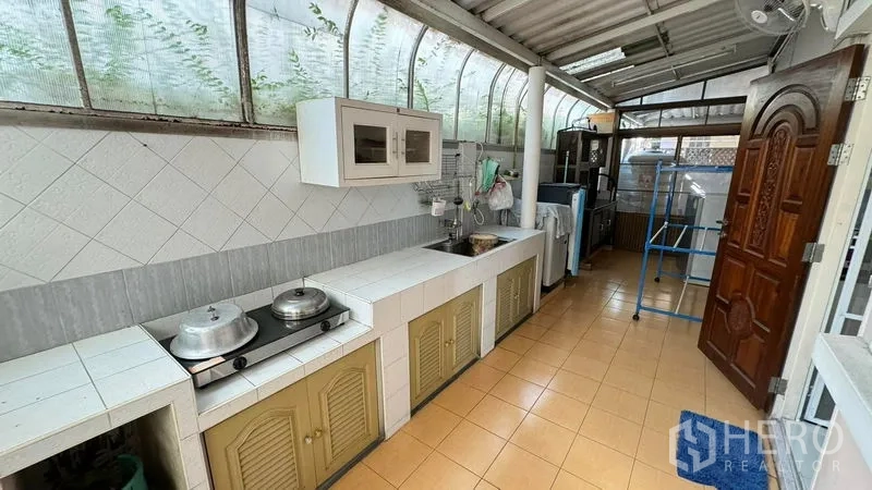 独立式住宅 出售在Mueang Pathum Thani, Pathum Thani - 带顶棚的户外泰式厨房，长操作台、水槽与储物柜。