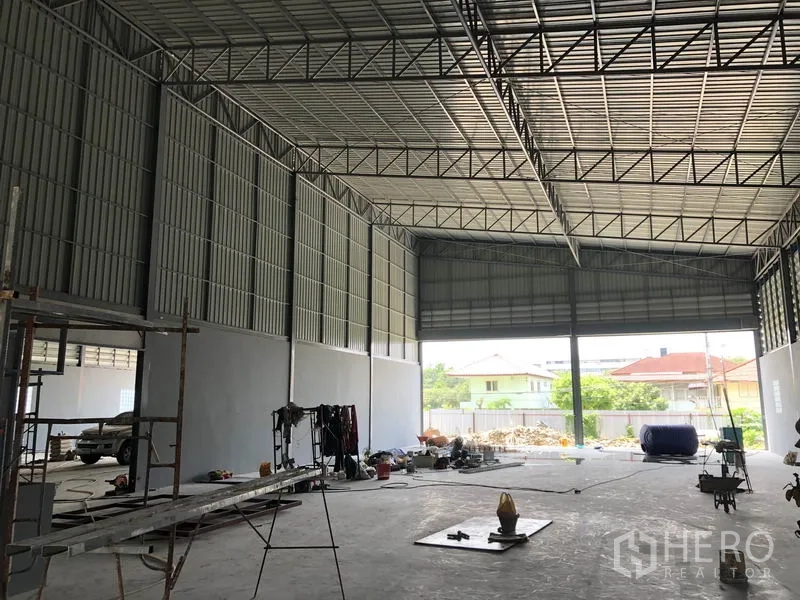คลังสินค้า ให้เช่าในBang Khen, Nonthaburi - มุมมองไปยังประตูม้วนขนาดใหญ่เปิดสู่ลาน พร้อมแสงธรรมชาติ