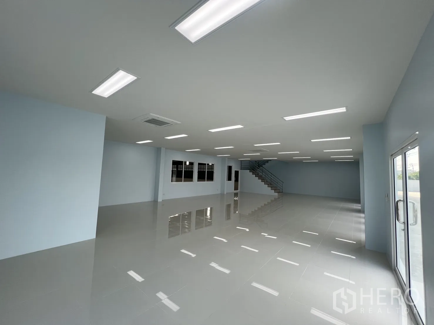 Warehouse for rent in Mueang Samut Prakan, Samut Prakan - Ground-floor office interior with glossy tiles, LED lighting and glass entry doors.