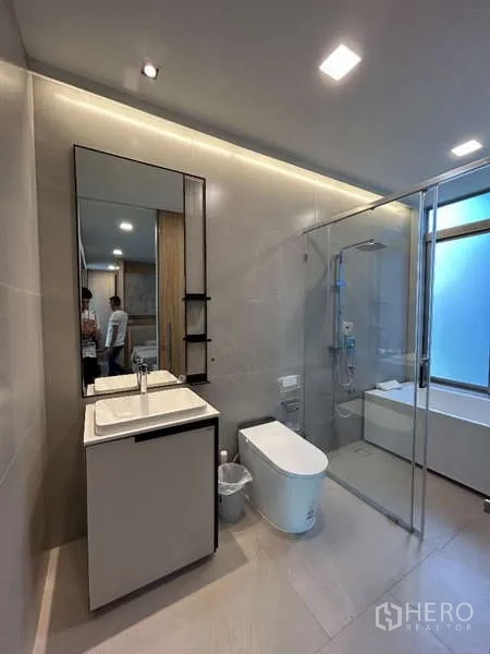 Detached House for rent in Saphan Sung, Bangkok - Sleek bathroom with glass shower, backlit mirror and modern sanitary ware.