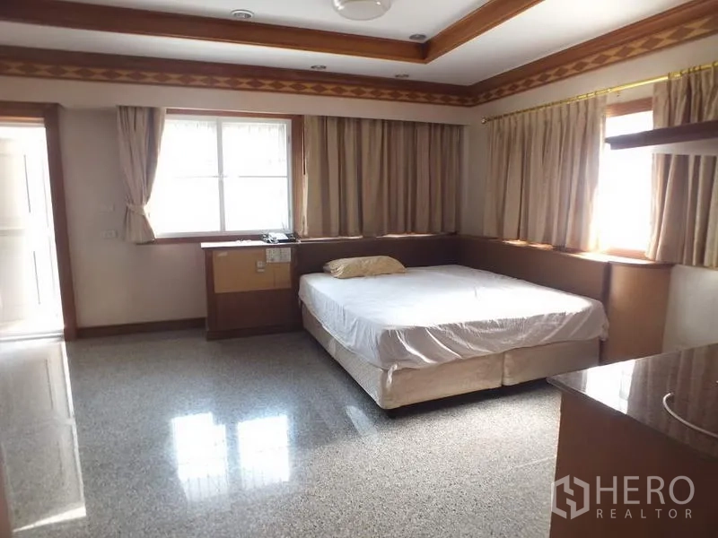 独立式住宅 出租在Bang Rak, Bangkok - 明亮卧室，双人床、大窗与木质线条装饰。