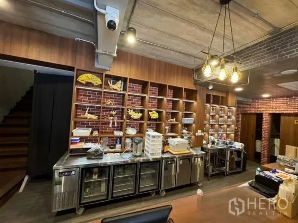 Shophouse for rent in Watthana, Bangkok - Service counter with open wood shelving, brick accents and stainless undercounter fridges.