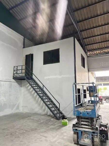 工厂 出租在Samut Prakan - 厂内两层办公室盒体，带金属楼梯，旁为装卸区与高屋顶。