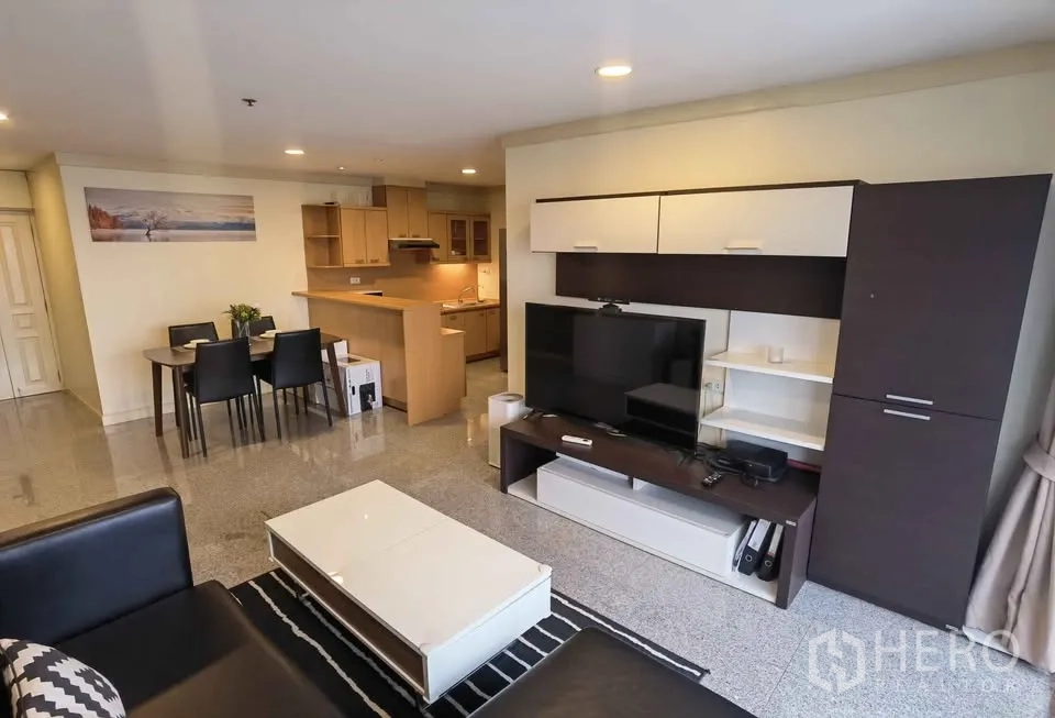 คอนโด for rent in Khlong Toei, Bangkok - พื้นที่นั่งเล่นกว้างขวางพร้อมชุดทีวี ชุดทานอาหาร และครัวแบบเปิด.