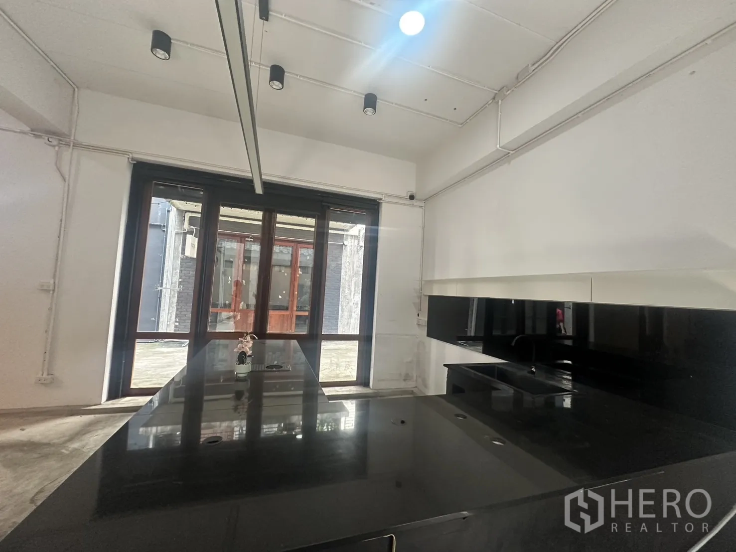 带办公室的家 出租在Pathum Wan, Bangkok - 面向整面玻璃的柜台与展示区，木框玻璃门相连。