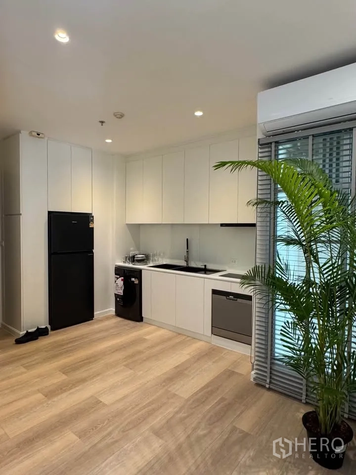 คอนโด for rent in Ratchathewi, Bangkok - ครัวแบบเปิด พื้นไม้ กระถางต้นไม้ และประตูสไลด์ออกสู่ระเบียง