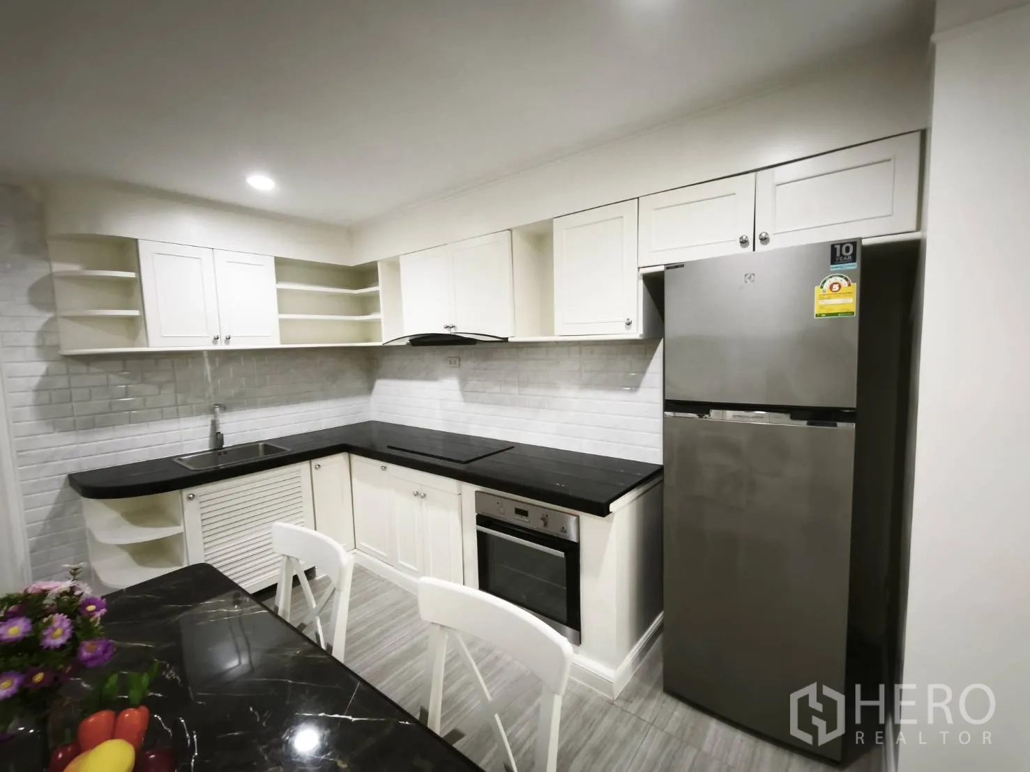 คอนโด for rent in Watthana, Bangkok - ครัวมุมแอลพร้อมเตาอบ เตาไฟฟ้า เครื่องดูดควัน และตู้เย็นสแตนเลส