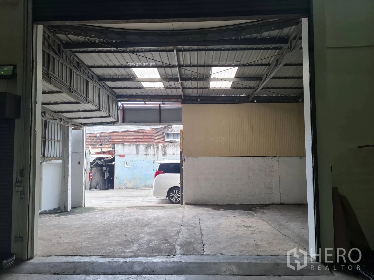 Warehouse for rent in Phra Pradaeng, Samut Prakan - Covered loading bay with wide roller door opening to driveway.