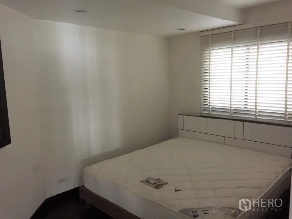 Condominium for rent in Sathon, Bangkok - Cozy bedroom with large window and white blinds, queen mattress and minimalist headboard.