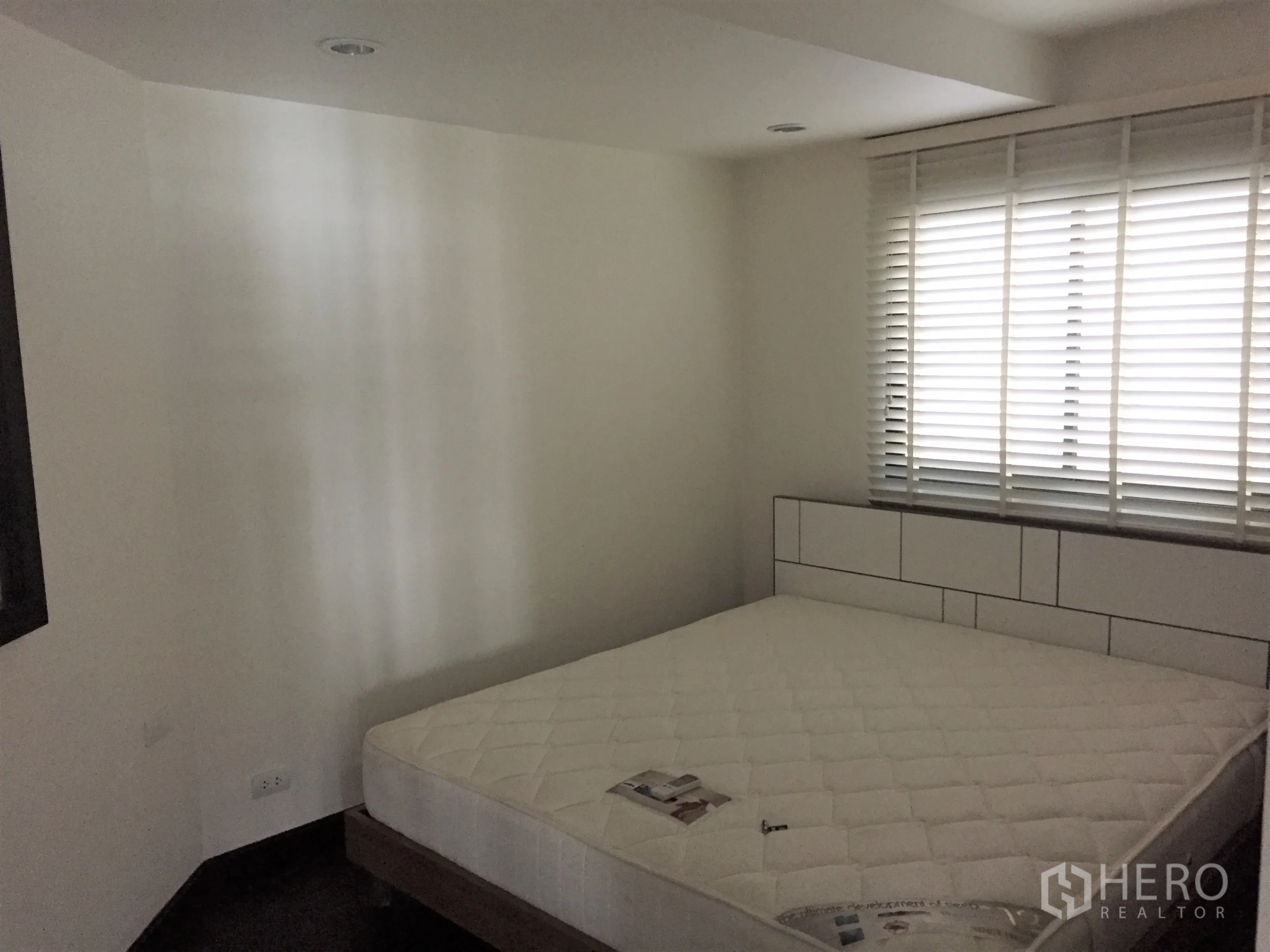 Condominium for rent in Sathon, Bangkok - Cozy bedroom with large window and white blinds, queen mattress and minimalist headboard.