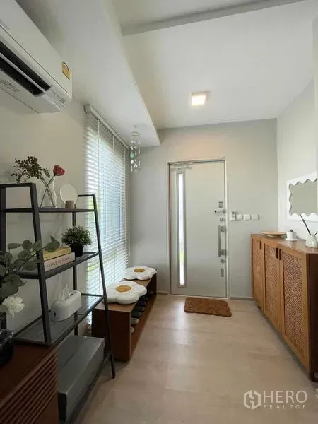 独立式住宅 出租或出售在Prawet, Bangkok - 入户玄关，置物架、换鞋凳、空调与玻璃入户门，色调清新。