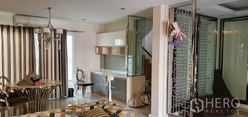 Detached House for sale in Khan Na Yao, Bangkok - Open-plan living and dining space with chandelier, compact pantry and staircase.