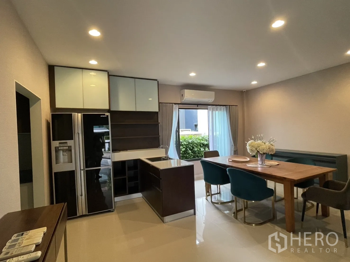 บ้าน ให้เช่าในBang Kapi, Bangkok - มุมครัวและห้องทานข้าวแบบโอเพนแปลนพร้อมตู้เย็นใหญ่และวิวสวน