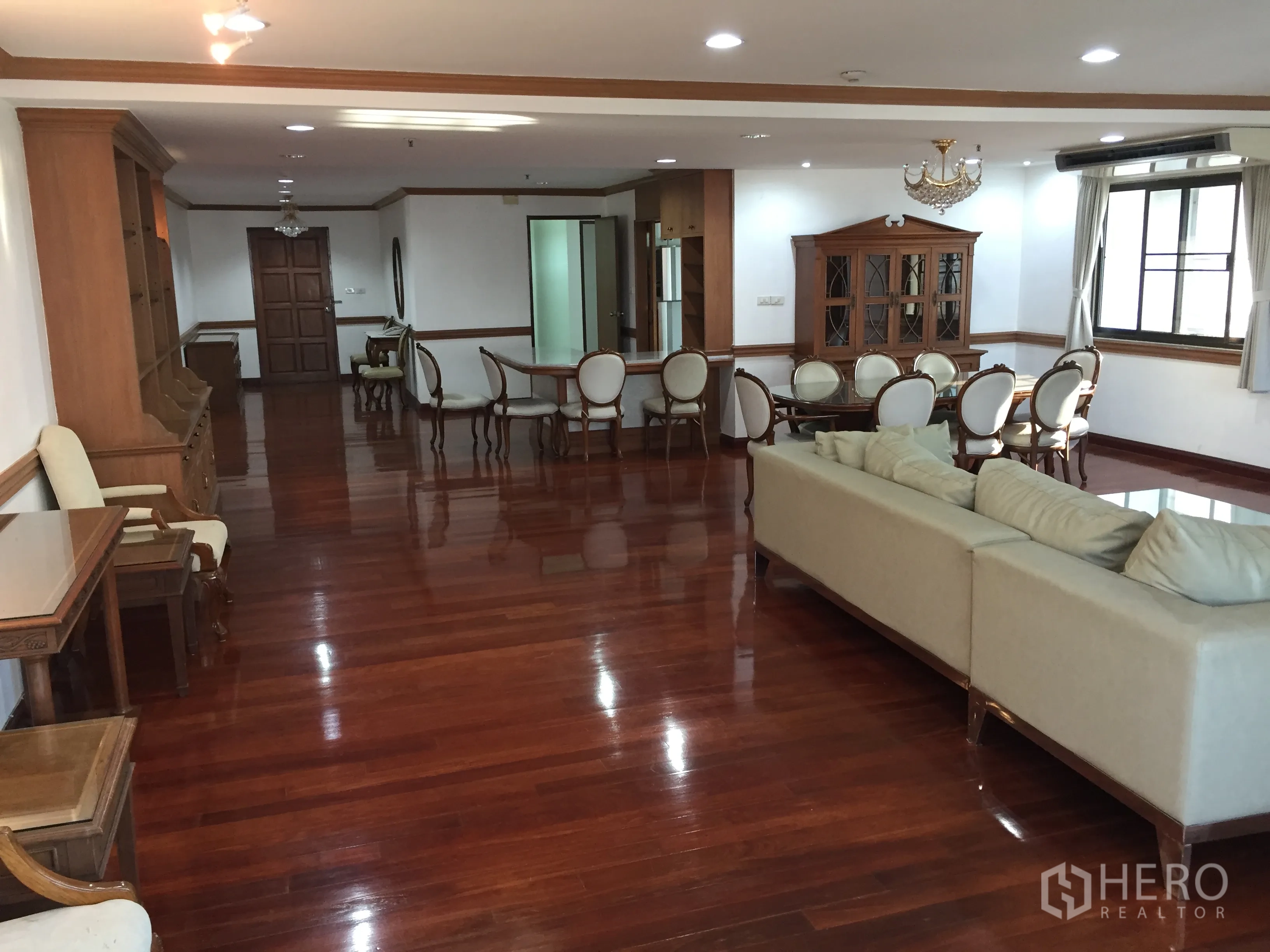 公寓 出租在Watthana, Bangkok - 开放式客餐厅，设沙发、吊灯与木地板。