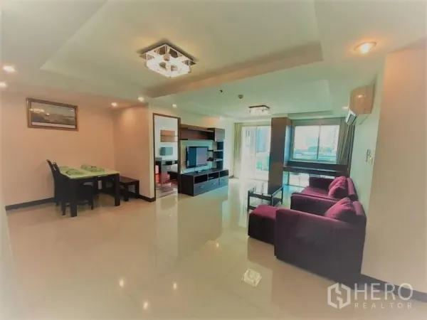 公寓 出租在Watthana, Bangkok - 明亮客厅，亮面地砖，电视墙与阳台落地门