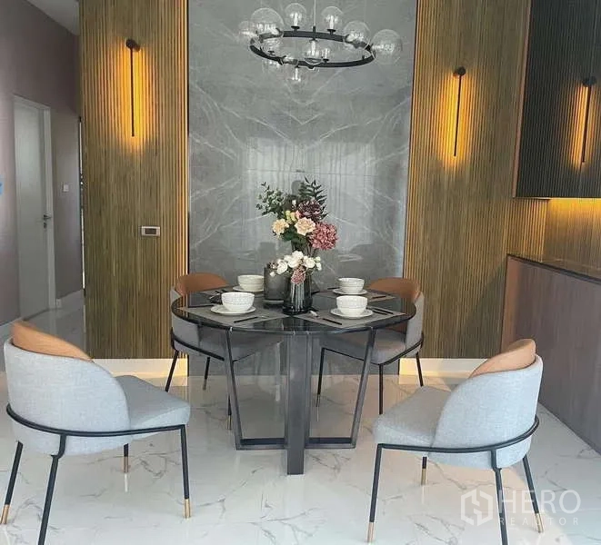 独立式住宅 出租在Bang Phli, Samut Prakan - 圆形餐桌摆设，灰色大理石背景墙与壁灯。