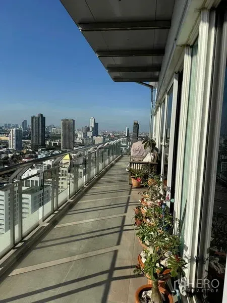 公寓 出租在Watthana, Bangkok - 环绕式长阳台，盆栽与玻璃护栏，享受全景天际线