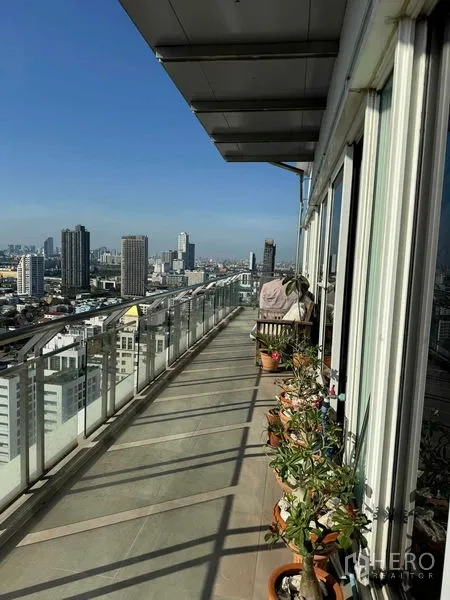 公寓 出租在Watthana, Bangkok - 环绕式长阳台，盆栽与玻璃护栏，享受全景天际线